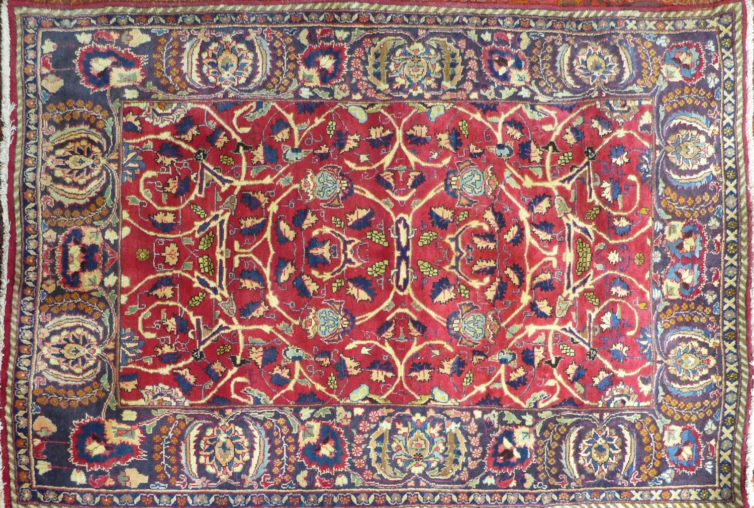 A Persian rug with floral motifs and spandrels on a red ground, contained by floral border, 200 x