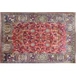 A Persian rug with floral motifs and spandrels on a red ground, contained by floral border, 200 x