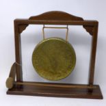 An early 20th century brass gong on oak stand, H.35 W.39 D.10cm