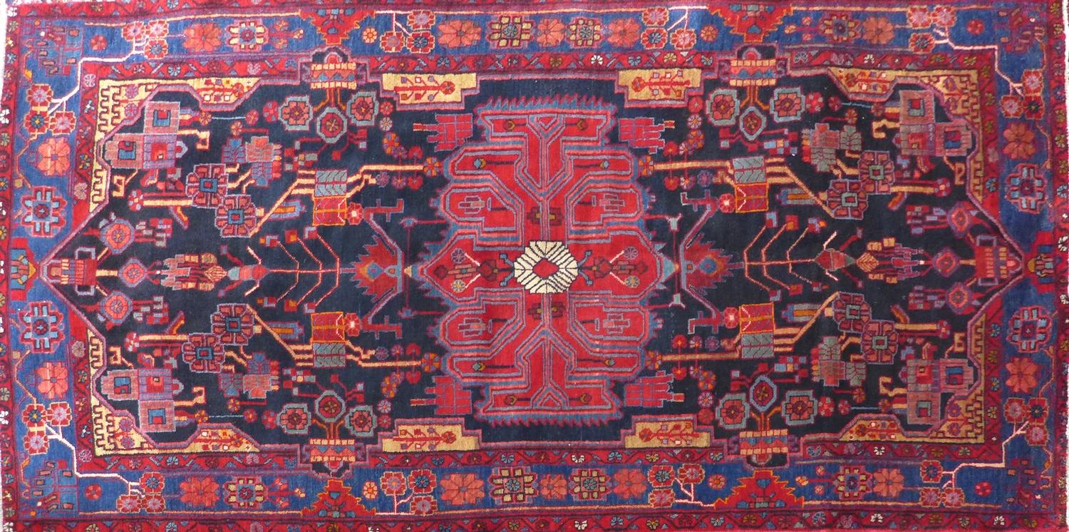 A North West Persian Nahawand rug, central diamond medallion with repeating petal motifs on a