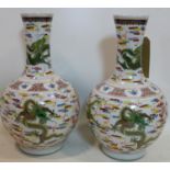 A pair of Chinese, Republic period famille rose bottle vases decorated with dragons chasing the
