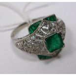 A platinum emerald and diamond ring centrally set with a square stepped-cut emerald to further