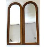 A pair of early 20th century mahogany arch topped mirrors with bevelled plates, 64 x 23cm