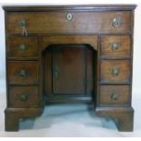 A Georgian oak kneehole desk, with 7 drawers and central cupboard door, raised on bracket feet, H.75