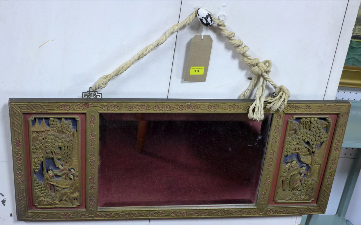 An early 20th century Chinese gilt hardwood framed mirror, with carved panels and bevelled plate, 35