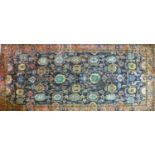 A 20th century Iranian carpet with repeating floral motifs, on a blue ground, contained by floral