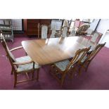 An Ercol dining table with two extra leaves, H: 74 W: 250 D: 101cm, together with 6 matching