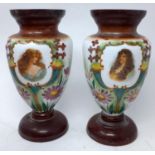 A pair of Bohemian opaque glass vases, hand painted with vignettes of ladies and stylised flowers,