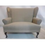 A two seater wingback sofa, raised on cabriole feet, H.107 W.128 D.68cm