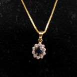 A boxed 9ct yellow gold, sapphire and brilliant-cut diamond cluster pendant on a 9ct yellow gold