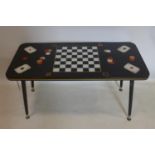 A vintage 1950's/60's coffee table the top adorned with playing cards and a printed chess board on