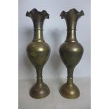 Two brass vases with wavy rims, the bodies and bases with stylised floral engraving, H.62cm