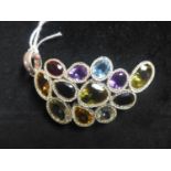 A sterling silver palmette pendant set with faceted citrine, blue topaz, garnet, amethyst, smokey