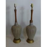 A pair of table lamps with teak stems and stoneware bodies on tapering gilt bases, H.73cm (2)