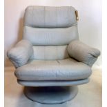 A pale grey leather armchair on a circular base, 93 x 81cm