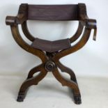 A late 19th century oak Savonarola chair with paw feet