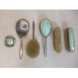 A guilloche enamelled dressing set, comprising a hand mirror, four brushes and matching ashtray, (6)