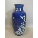 An early 20th century Chinese vase with a dark blue ground and white flowers in raised relief,