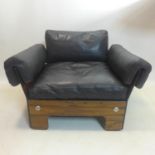 A 1970's Danish style exotic hardwood armchair, with black leather upholstery and chromium bolts,