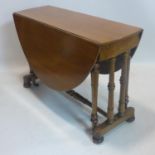 A 19th century walnut drop leaf gateleg table, on turned supports and stretcher, raised on bun
