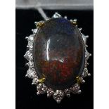 A boxed 18ct white gold natural black opal and brilliant-cut diamond ring, the central oval cabochon