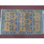 A 20th century small Turkish rug, with geometric design, on an orange and blue ground, 125 x 74cm