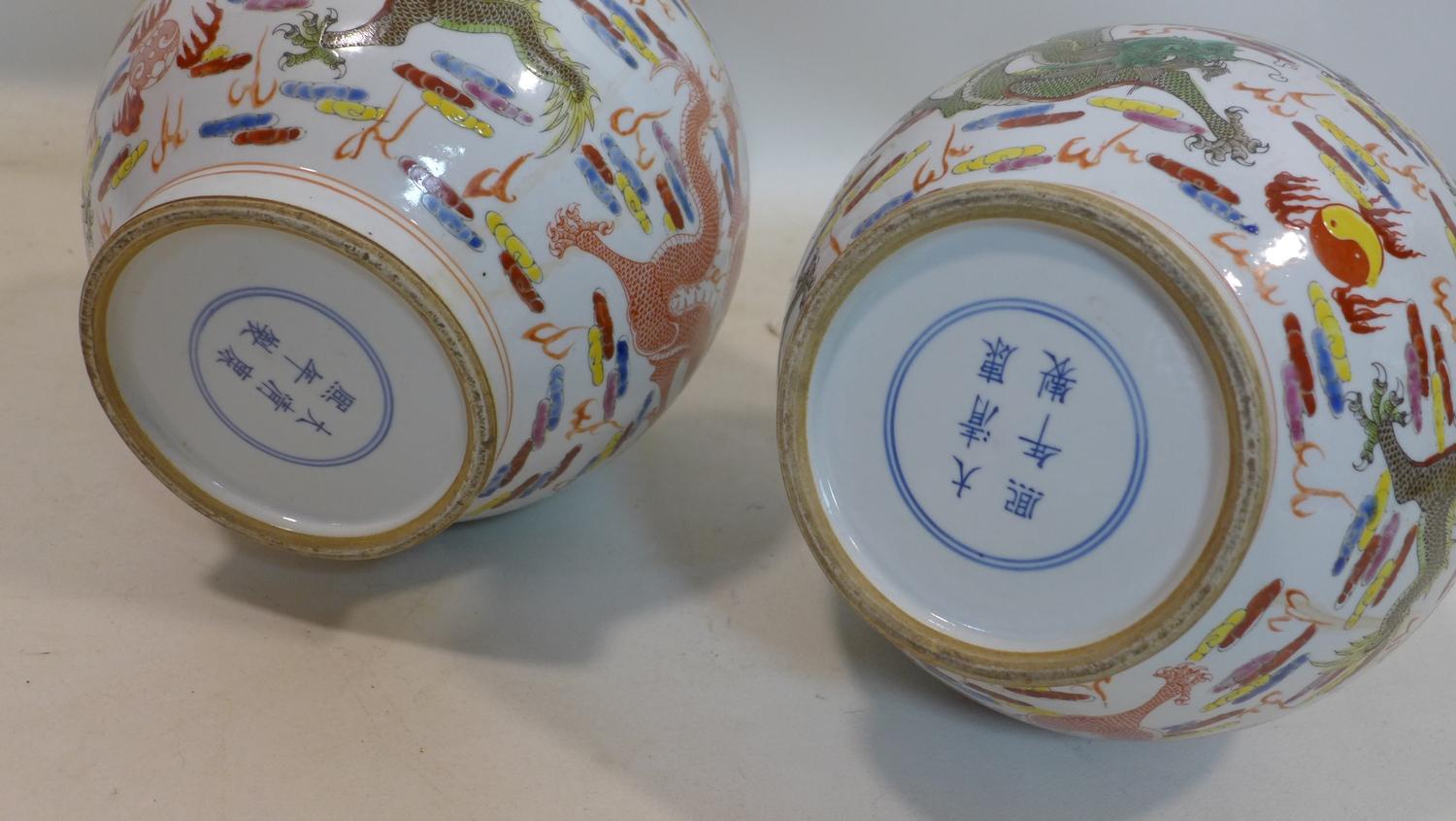 A pair of Chinese, Republic period famille rose bottle vases decorated with dragons chasing the - Image 3 of 3