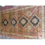 A South West Persian Lori carpet, repeating stylised diamond medallion on a terracotta field,