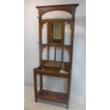 An Arts & Crafts oak hall stand with bevelled mirror back plate