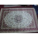 A Kashan style carpet with central floral medallion, on a beige ground, contained by floral borders,