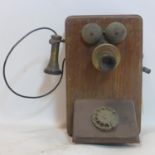 A vintage oak wall hanging telephone by the western electric company