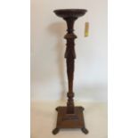 A Victorian carved oak torchere stand, decorated with swags and raised on paw feet, H.127cm