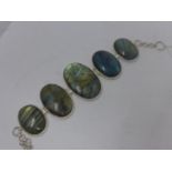 A sterling silver and labradorite bracelet composed of 5 oval, polished labradorite cabochon