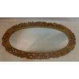 A large oval mirror in a hand-carved pine frame decorated with foliage and ears of corn, H: 135 x W: