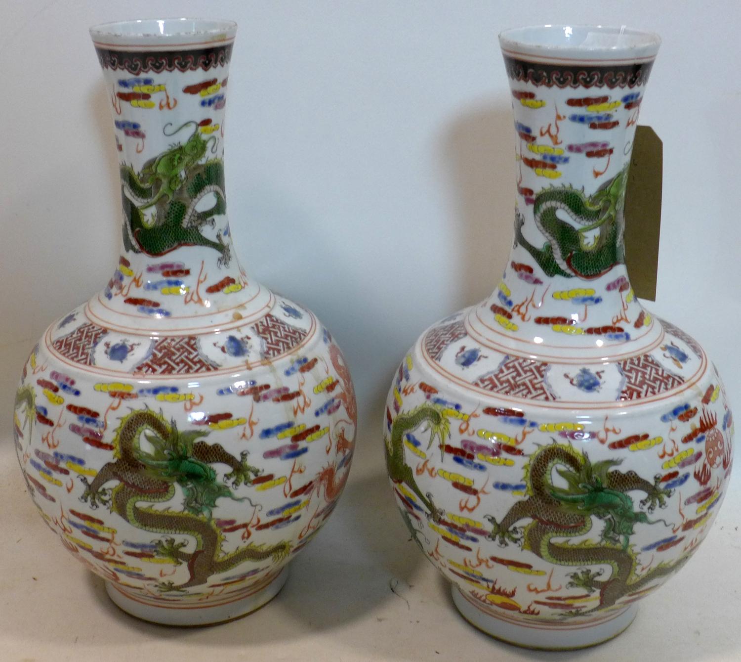 A pair of Chinese, Republic period famille rose bottle vases decorated with dragons chasing the - Image 2 of 3