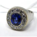 An 18ct white gold brilliant-cut diamond and sapphire ring set to the centre with a faceted oval