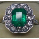 An 18ct white gold emerald and diamond cluster ring centrally set with a stepped-cut rectangular