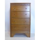 An oak chest of four drawers, the hinged top with fitted mirror to interior, raised on four