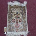 An antique silk Turkish Hereke rug with vase of flower design, on beige ground, signed, 73 x 47cm