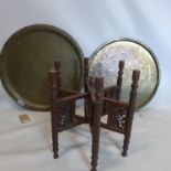 A nomads table with carved hexagonal wooden base and brass top, Diameter 66cm, together with an