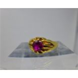 A 22ct yellow gold ring multi claw-set to the centre with a round faceted natural Burmese ruby