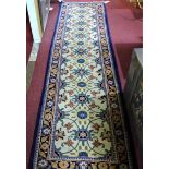 A signed Persian runner, with floral motifs on a cream field, within floral border on a blue