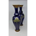 A pair of early 20th century Art Nouveau Royal Doulton blue glazed vases, decorated with flowers,