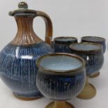 A set of 12 Eeles Family Pottery wine goblets with a matching jug, H.13cm (goblets), H.23cm (jug) (