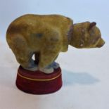 An early 20th century, German nodding toy in the form of a circus bear on red velvet podium, H: 18 x