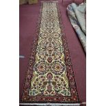 A North West Persian Rudbar runner, repeating stylised floral motifs on an ivory field, within