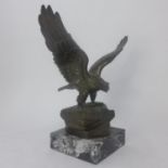 A bronze eagle on naturalistic base, raised on marble base, H.22 W.24cm
