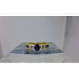 An 18ct yellow gold diamond and sapphire ring set with an oval faceted sapphire to the centre