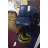A vintage Estee Lauder make-up artist's chair with brass clad swivel base and navy leather