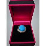A 14ct white gold diamond and turquoise ring centrally set with a large oval turquoise cabochon